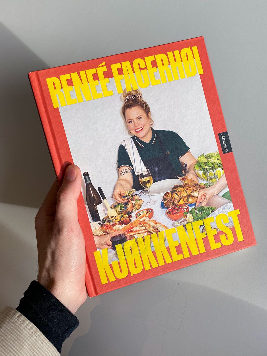 Photo of orange cookbook held by sexy hands